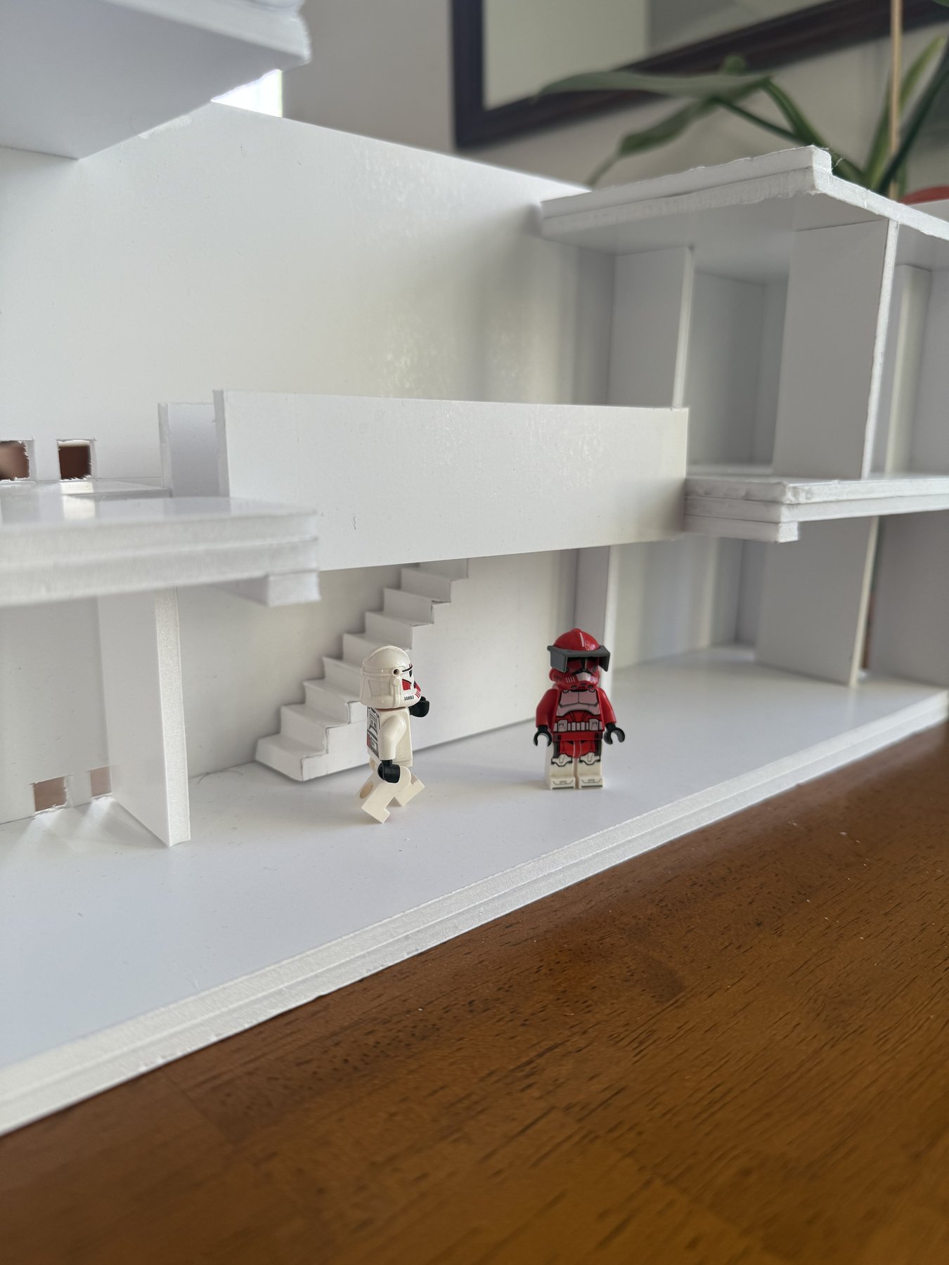 Cantilevered floor plate and switchback stair in the physical model, with figures placed for scale.
