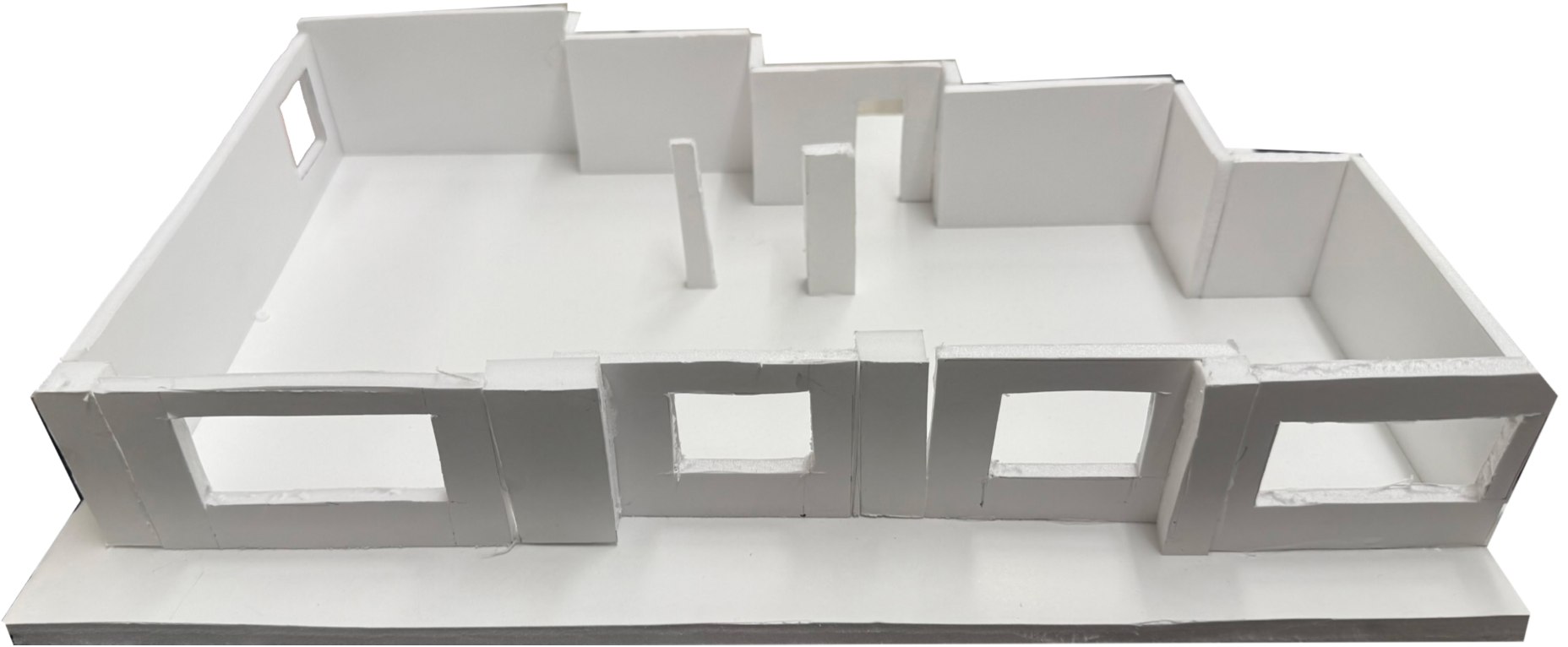 White foam-board study model seen from the window wall, with four window openings.